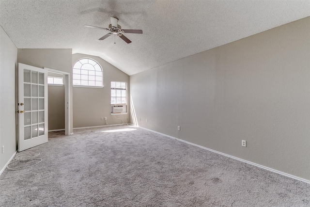 carpeted empty room featuring baseboards, vaulted ceiling, cooling unit, a textured ceiling, and a ceiling fan