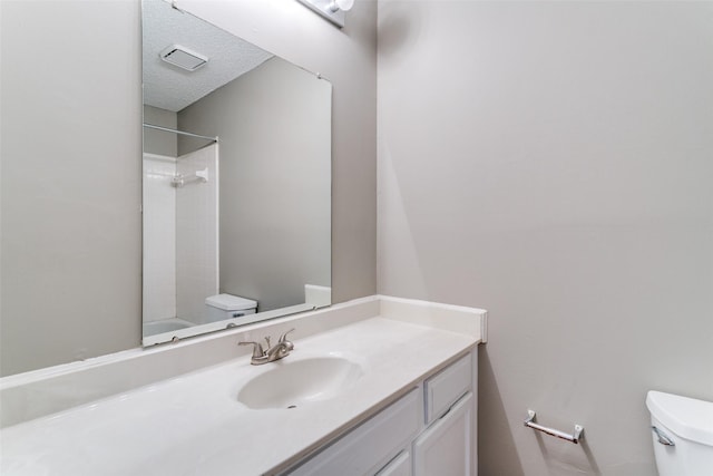 full bathroom featuring visible vents, a textured ceiling, toilet, and vanity