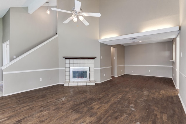 unfurnished living room featuring a ceiling fan, wood finished floors, baseboards, and a tile fireplace