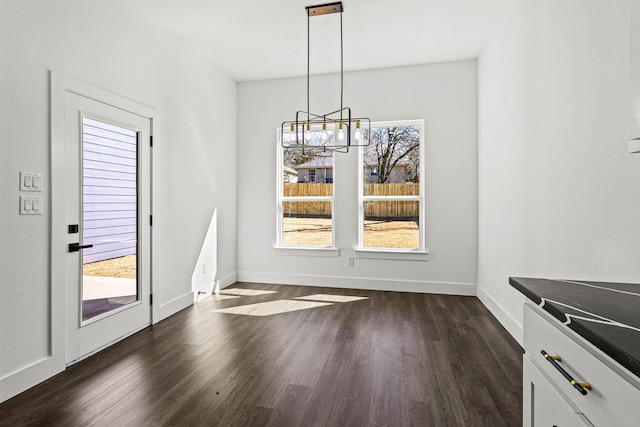 unfurnished dining area featuring dark wood-style floors, plenty of natural light, and baseboards