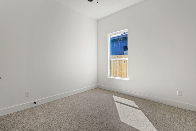 carpeted empty room with ceiling fan and baseboards