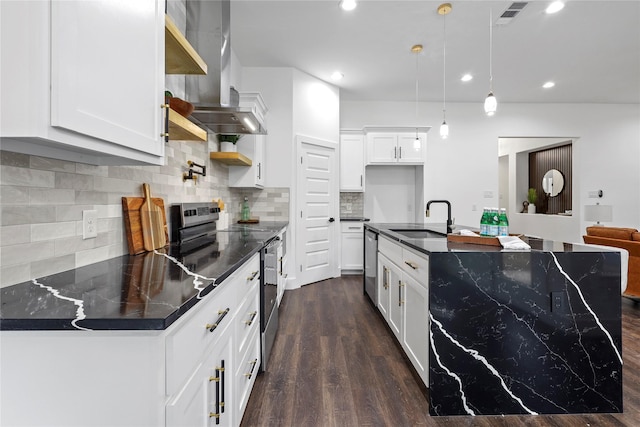 kitchen with visible vents, dark countertops, appliances with stainless steel finishes, wall chimney range hood, and a sink