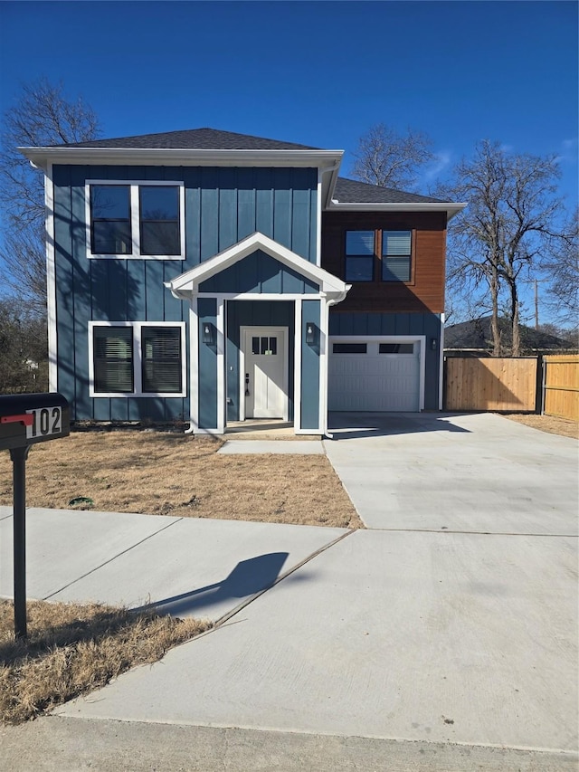 modern home featuring driveway, an attached garage, fence, and board and batten siding