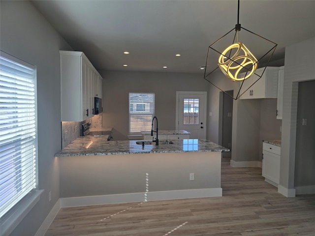 kitchen with white cabinetry, a sink, a peninsula, and electric range oven