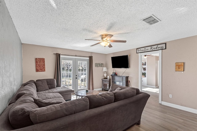 living area with visible vents, baseboards, ceiling fan, french doors, and light wood-type flooring