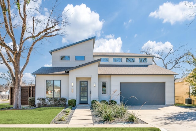 view of front of house featuring concrete driveway, roof with shingles, an attached garage, cooling unit, and a front yard