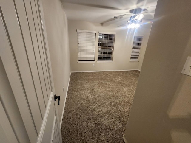 empty room with carpet, baseboards, and ceiling fan