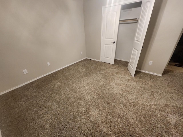 unfurnished bedroom with carpet floors, a closet, and baseboards