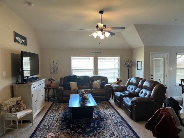 living room featuring plenty of natural light, a ceiling fan, vaulted ceiling, and carpet flooring