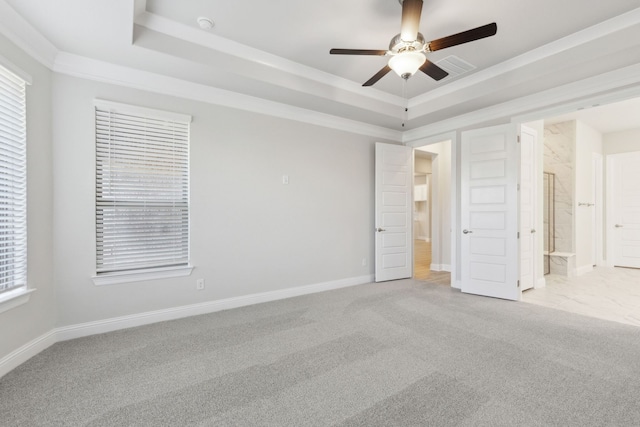 unfurnished bedroom with ornamental molding, a raised ceiling, light colored carpet, and baseboards