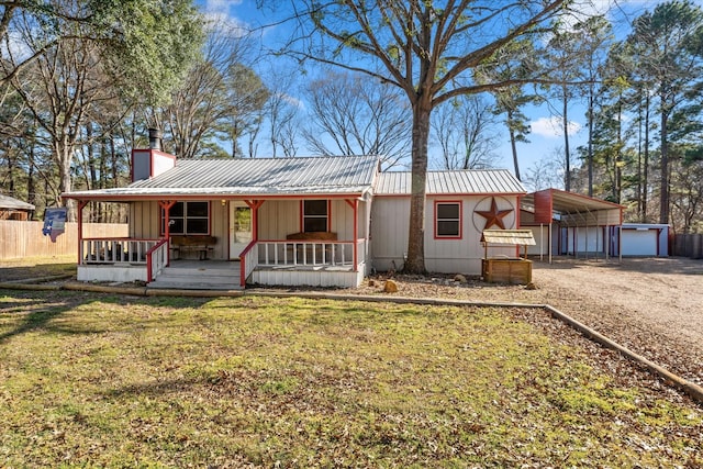 manufactured / mobile home with metal roof, a chimney, a porch, and a front yard