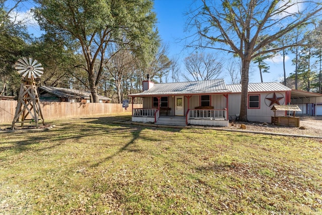 rear view of house featuring covered porch, a chimney, fence, metal roof, and board and batten siding
