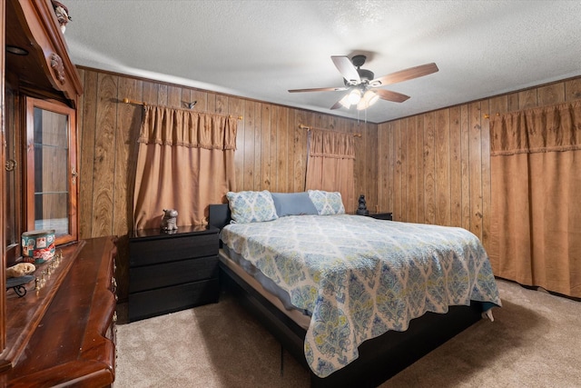 bedroom with a textured ceiling, wooden walls, and carpet
