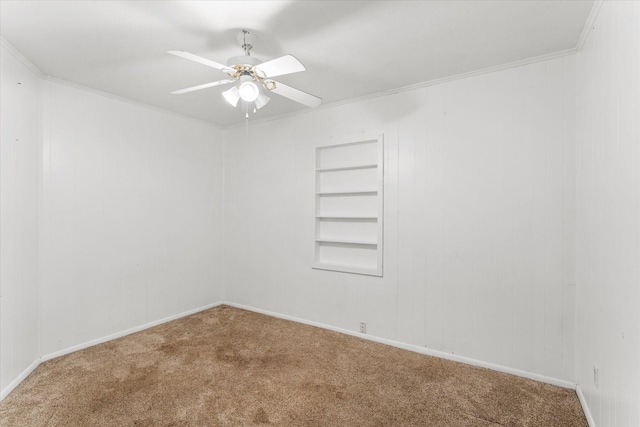 carpeted empty room featuring crown molding, baseboards, a ceiling fan, and built in features