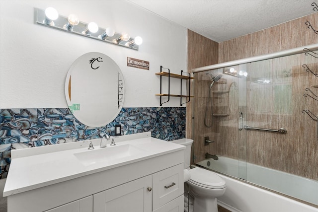 full bathroom featuring a textured ceiling, toilet, vanity, and combined bath / shower with glass door
