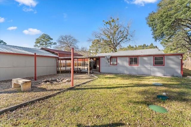 rear view of house with a yard and metal roof