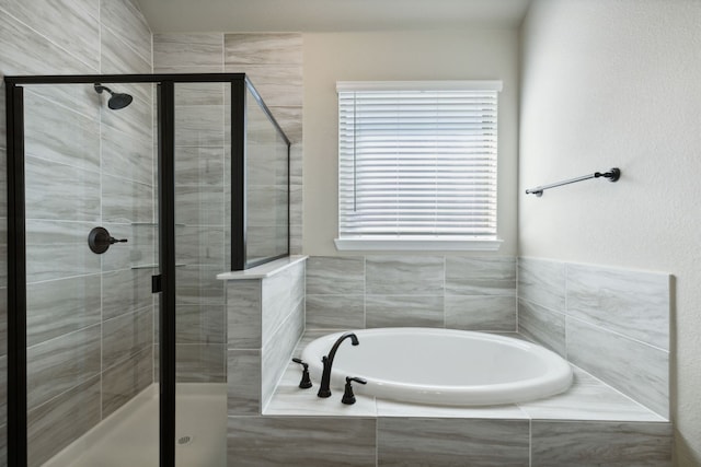 full bathroom featuring a stall shower and a garden tub