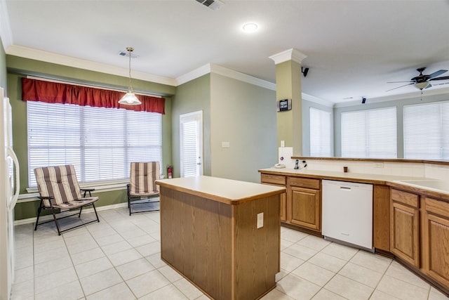 kitchen featuring brown cabinets, light countertops, hanging light fixtures, a kitchen island, and white appliances