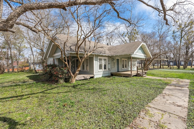 view of front of property featuring a front lawn, a porch, and a shingled roof