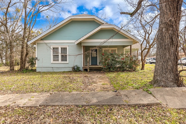 bungalow featuring a front yard and covered porch