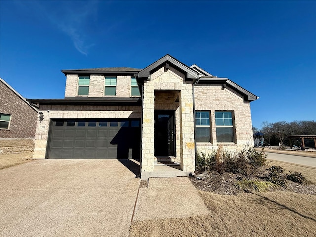 view of front of house featuring stone siding, brick siding, driveway, and an attached garage