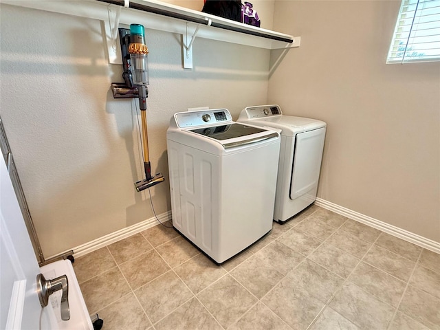 clothes washing area featuring baseboards, laundry area, light tile patterned floors, and washer and dryer