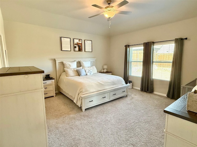 bedroom featuring ceiling fan, baseboards, and light colored carpet