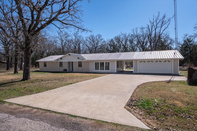 single story home featuring metal roof, concrete driveway, and a front yard