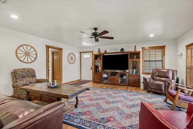 living room featuring light wood-style floors, baseboards, a ceiling fan, and recessed lighting