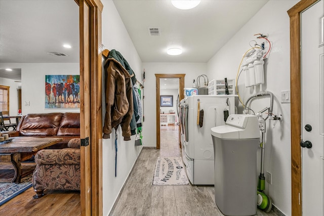 laundry room featuring laundry area, visible vents, light wood-style flooring, and washing machine and clothes dryer