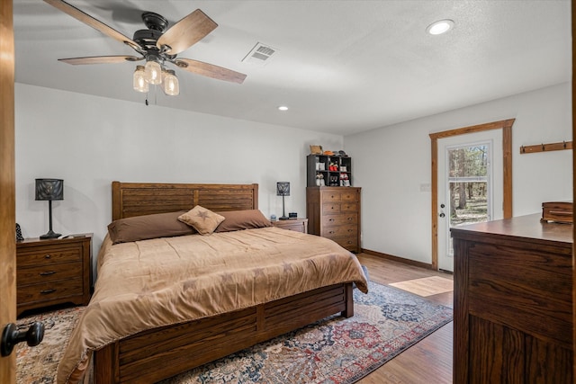 bedroom featuring ceiling fan, light wood-style flooring, recessed lighting, visible vents, and access to outside