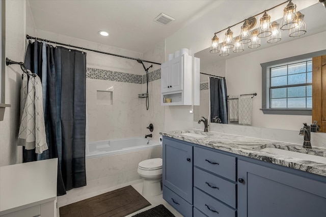 bathroom featuring visible vents, a sink, tiled shower / bath combo, and double vanity