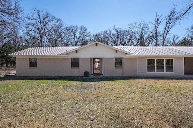 single story home with metal roof and a front lawn