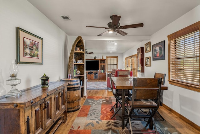 dining room featuring visible vents, ceiling fan, and wood finished floors