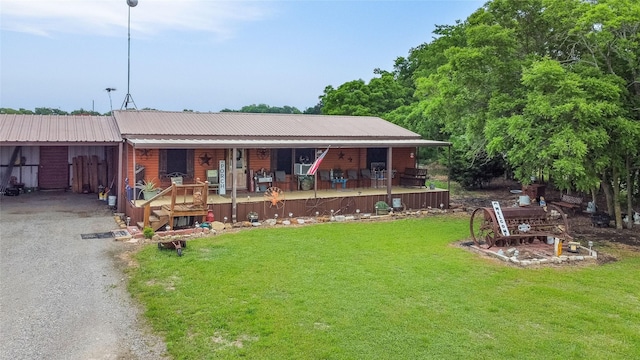 view of front of property featuring metal roof, a porch, a carport, a front lawn, and gravel driveway