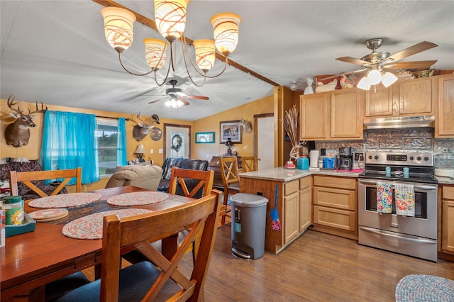 kitchen with under cabinet range hood, light countertops, electric stove, and light brown cabinetry