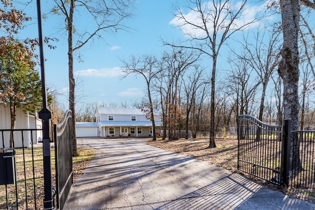 view of front of house featuring a garage, driveway, a fenced front yard, and a gate