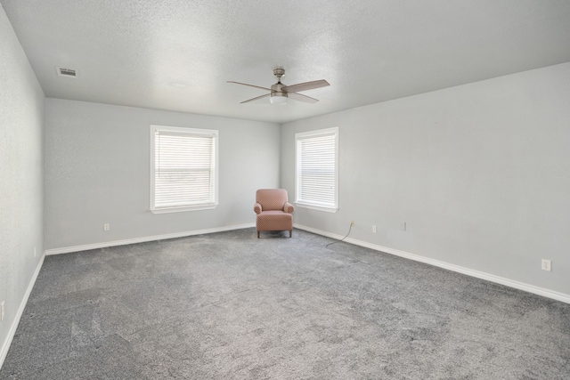 unfurnished room featuring a textured ceiling, visible vents, and a healthy amount of sunlight