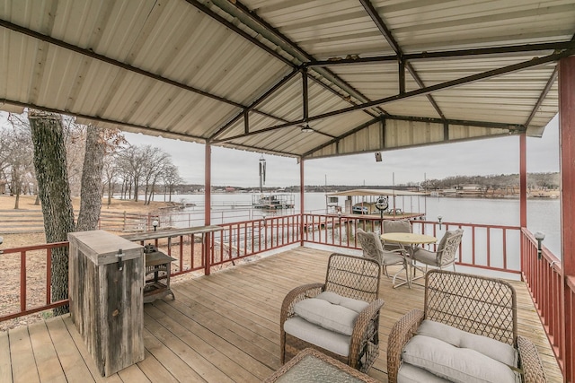 wooden deck featuring a water view, outdoor dining space, and a gazebo