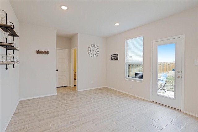 spare room featuring light wood-style floors, recessed lighting, and baseboards