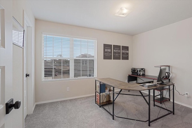 home office with baseboards and light colored carpet