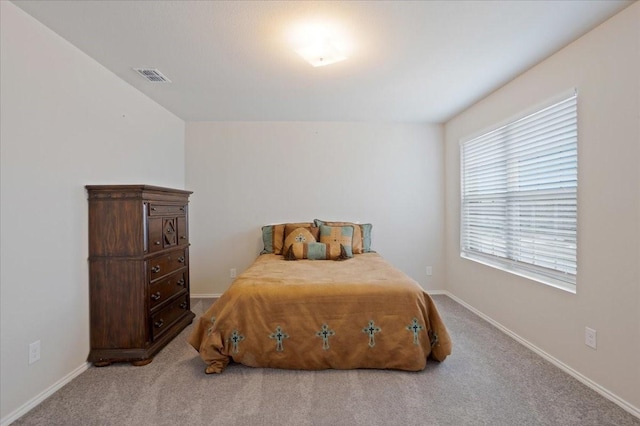 bedroom with baseboards, visible vents, and light colored carpet