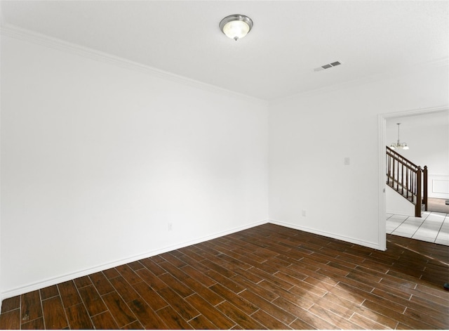 unfurnished room with dark wood-style flooring, visible vents, crown molding, and baseboards