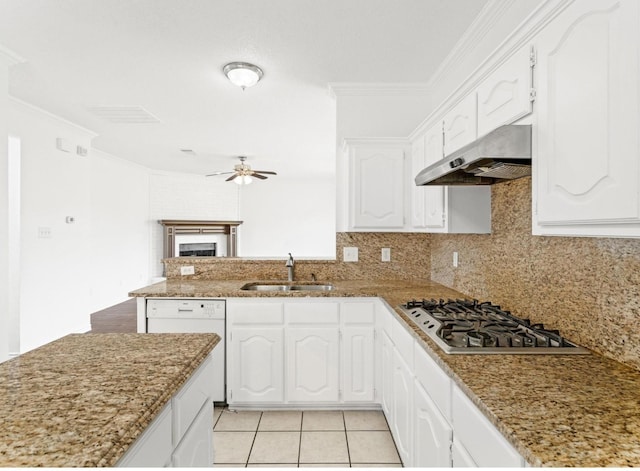 kitchen with white dishwasher, under cabinet range hood, stainless steel gas cooktop, a sink, and white cabinets