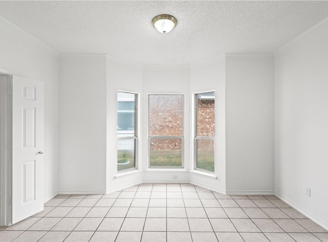 spare room featuring a textured ceiling, baseboards, light tile patterned flooring, and crown molding