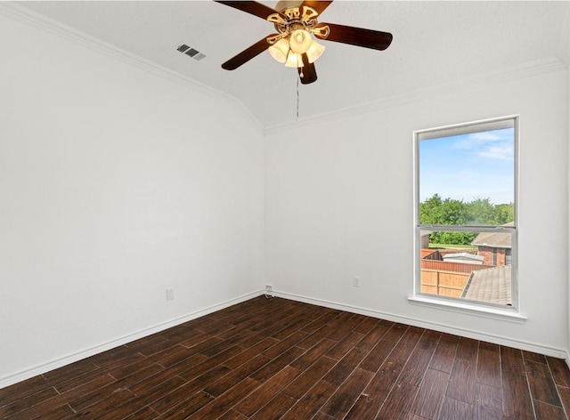 spare room featuring dark wood-style floors, vaulted ceiling, visible vents, and crown molding