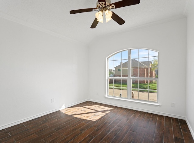 empty room featuring a ceiling fan, dark wood-style flooring, crown molding, and baseboards