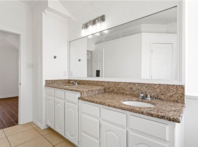 full bath featuring double vanity, tile patterned flooring, ornamental molding, and a sink