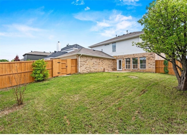 view of yard featuring a fenced backyard and a gate