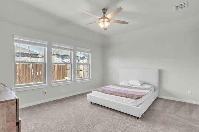 carpeted bedroom with ceiling fan, visible vents, and baseboards